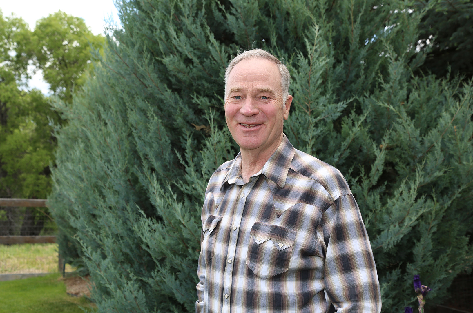 Dave Kinskey posing in front of an evergreen