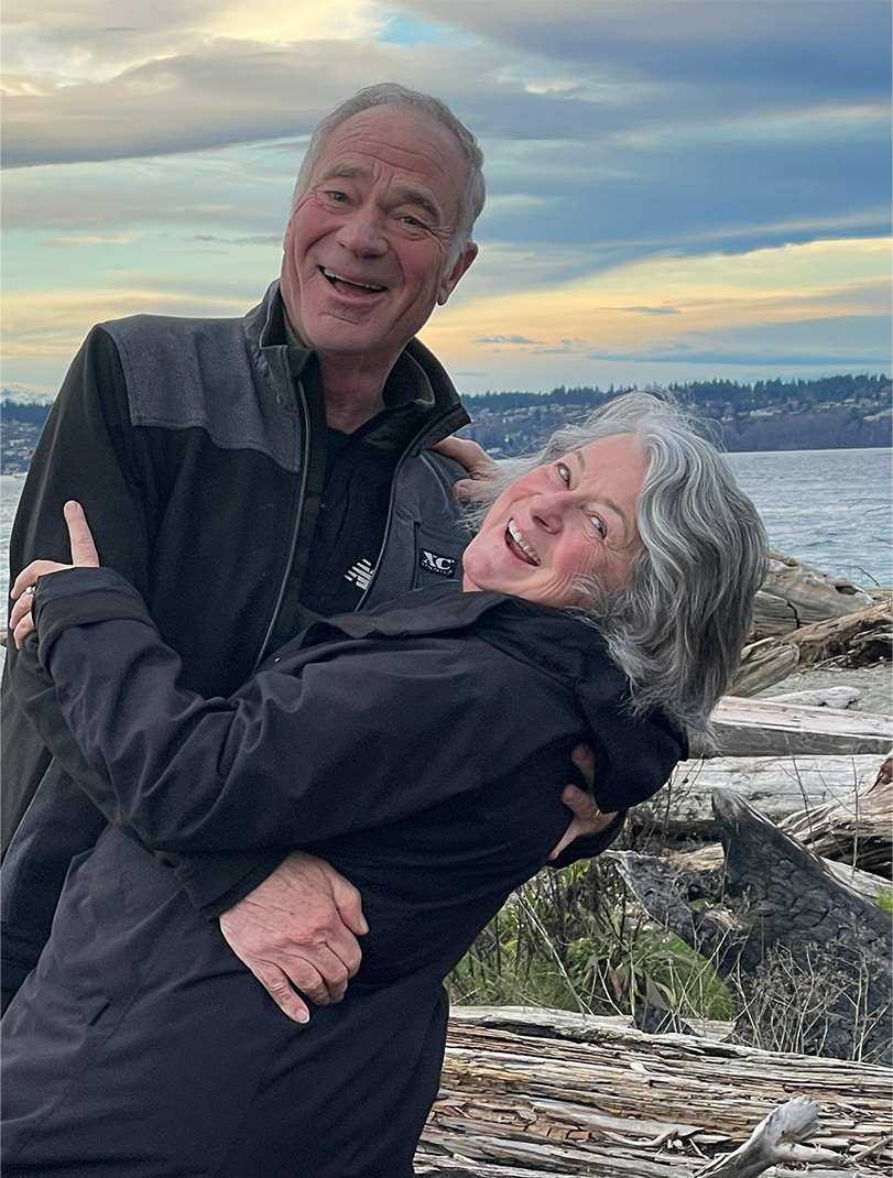 Dave Kinskey holding his wife in front of a body of water